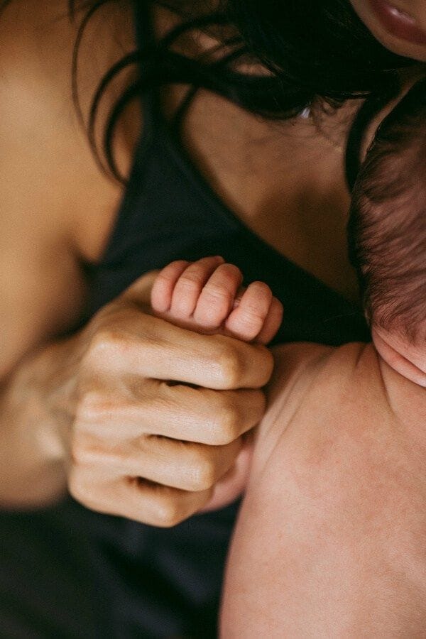 A mother holding her newborn, doing better than she thinks